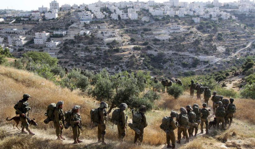 TOPSHOT - Israeli soldiers walk in a single file on a path during an operation in the West Bank town of Hebron on June 17, 2014 as Israeli forces broadened the search for three teenagers believed kidnapped by militants and imposed a tight closure of the town. Israeli Prime Minister Benjamin Netanyahu demanded Palestinian president Mahmud Abbas's help in securing the release of three kidnapped teenagers, as the army launched a massive crackdown on Islamist movement Hamas. AFP PHOTO/ HAZEM BADER (Photo by HAZEM BADER / AFP) (Photo by HAZEM BADER/AFP via Getty Images)