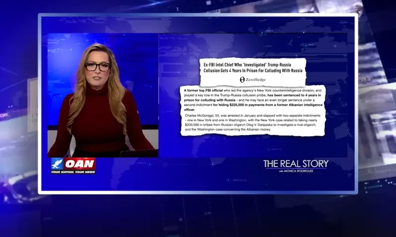 Video still of the host of The Real Story at the desk of their talk show on One America News Network.