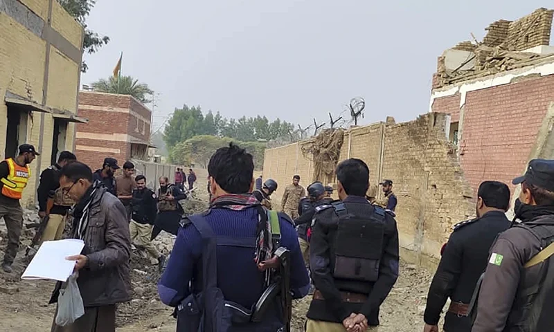 of 3 Security officials examine damages on the site of a bombing at a police station on the outskirts of Dera Ismail Khan, Pakistan, Tuesday, Dec. 12, 2023. A suicide bomber detonated his explosive-laden vehicle at a police station's main gate in northwest Pakistan on Tuesday, killing several policemen and wounding more than dozen others, officials said. Some militants also opened fire and a shootout between them and security forces was still ongoing, police officer Kamal Khan said. (AP Photo)