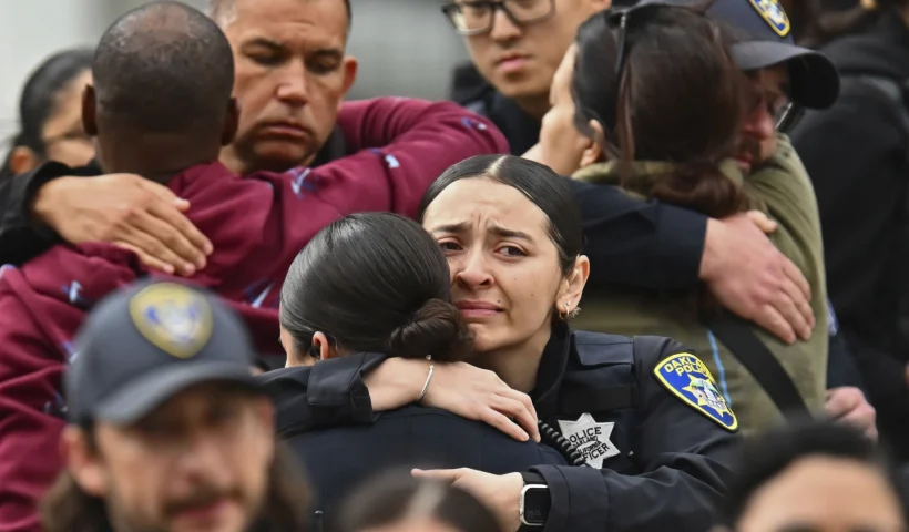 Oakland police officers console each other as they leave Highland Hospital in Oakland, Calif., on Friday, Dec. 29, 2023. An Oakland police officer was shot and killed Friday while answering a report of a burglary at a marijuana dispensary , authorities said. (Jose Carlos Fajardo/Bay Area News Group via AP)