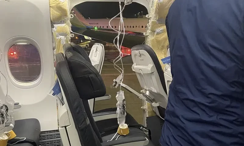 Passenger oxygen masks hang from the roof next to a missing window and a portion of a side wall of an Alaska Airlines Flight 1282, which had been bound for Ontario, California and suffered depressurization soon after departing, in Portland, Oregon, U.S., January 5, 2024 in this picture obtained from social media. Instagram/@strawberrvy via REUTERS/File Photo