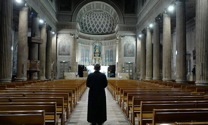TOPSHOT-FRANCE-HEALTH-VIRUS TOPSHOT - A priest prays in the French Riviera city of Nice, southern France, on March 27, 2020 as a strict lockdown is extended to stop the spread of the COVID-19 in the country. (Photo by VALERY HACHE / AFP) (Photo by VALERY HACHE/AFP via Getty Images)