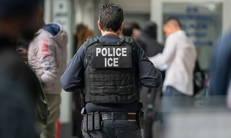 NEW YORK, NEW YORK - JUNE 6: An ICE agent monitors hundreds of asylum seekers being processed upon entering the Jacob K. Javits Federal Building on June 6, 2023 in New York City. New York City has provided sanctuary to over 46,000 asylum seekers since 2013, when the city passed a law prohibiting city agencies from cooperating with federal immigration enforcement agencies unless there is a warrant for the person's arrest.(Photo by David Dee Delgado/Getty Images)