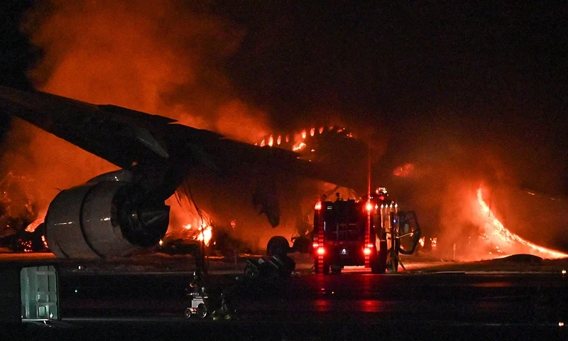 TOPSHOT - A Japan Airlines (JAL) passenger plane is seen on fire on the tarmac at Tokyo International Airport at Haneda on January 2, 2024. A Japan Airlines plane was in flames on the runway of Tokyo's Haneda Airport on January 2 after apparently colliding with a coast guard aircraft, television reports said. (Photo by Richard A. Brooks / AFP) (Photo by RICHARD A. BROOKS/AFP via Getty Images)