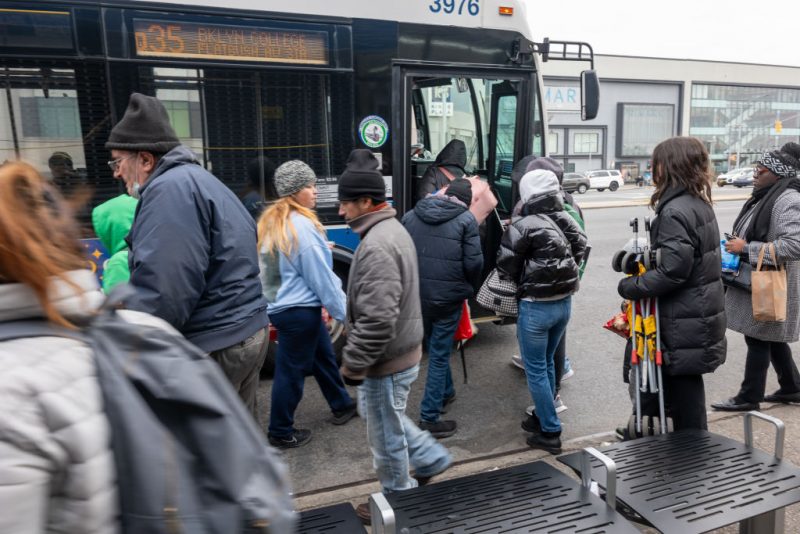 NEW YORK, NEW YORK - JANUARY 04: Recently arrived migrants board a bus back to their temporary tent shelters at Floyd Bennett Field, a former airfield in Brooklyn, on January 04, 2024 in New York City. The isolated location on a road that leads to the Atlantic Ocean has forced migrants to depend on limited sources of transportation to get to schools, work or other locations. The 2,000-bed shelter, which opened in November to house migrant families, was chosen after the Eric Adams administration said hotels and other places of shelter had hit capacity, after New York became the main destination for buses from Texas. (Photo by Spencer Platt/Getty Images)