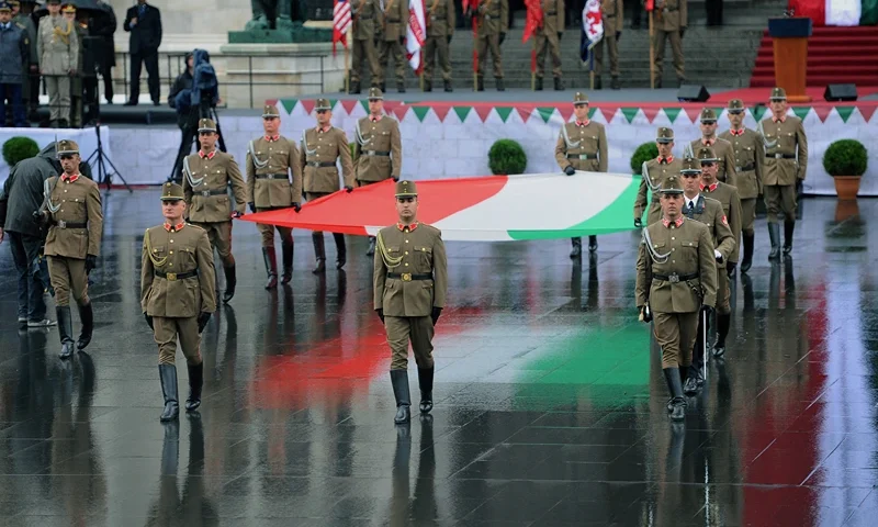 Hungarian soldiers march with the Hungarian national flag in front of the parliament building at the Kossuth square of Budapest on August 20, 2014 on Hungary's national day and during the ceremony of the 1014th anniversary of the Hungarian state's establishment. AFP PHOTO / ATTILA KISBENEDEK (Photo by ATTILA KISBENEDEK / AFP) (Photo by ATTILA KISBENEDEK/AFP via Getty Images)