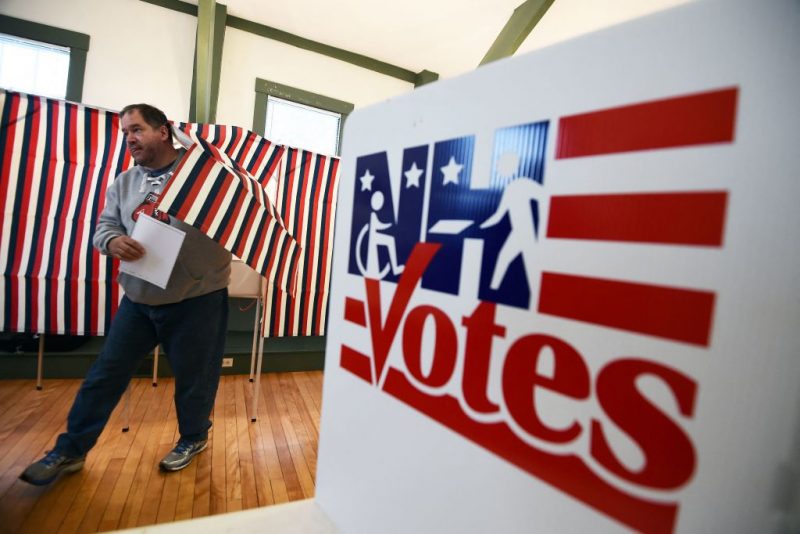 TOPSHOT - A man walks out of a booth with his ballot for the first US presidential primary at the town hall in Canterbury, New Hampshire, on February 9, 2016. - New Hampshire began voting on February 9 in the first US presidential primary with Republican Donald Trump calling on supporters to propel him to victory and Democrat Bernie Sanders primed to upstage Hillary Clinton. The northeastern state, home to just 1.3 million people, sets the tone for the primaries and could shake out a crowded Republican field of candidates pitting Trump and arch-conservative Senator Ted Cruz against more establishment candidates led by Senator Marco Rubio. (Photo by Jewel Samad / AFP) (Photo by JEWEL SAMAD/AFP via Getty Images)