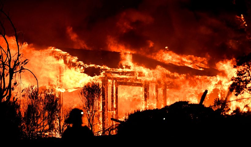 TOPSHOT - Firefighters assess the scene as a house burns in the Napa wine region of California on October 9, 2017, as multiple wind-driven fires continue to ravage the area burning structures and causing widespread evacuations. (Photo by AFP) (Photo by -/AFP via Getty Images)