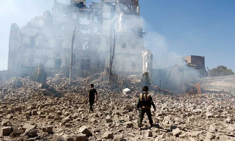 TOPSHOT-YEMEN-CONFLICT TOPSHOT - Huthi rebel fighters inspect the damage after a reported air strike carried out by the Saudi-led coalition targeted the presidential palace in the Yemeni capital Sanaa on December 5, 2017. Saudi-led warplanes pounded the rebel-held capital before dawn after the rebels killed former president Ali Abdullah Saleh as he fled the city following the collapse of their uneasy alliance, residents said. (Photo by Mohammed HUWAIS / AFP) (Photo by MOHAMMED HUWAIS/AFP via Getty Images)