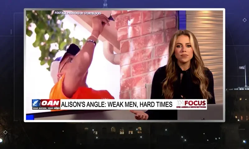 Video still of the host of In Focus at the desk of their talk show on One America News Network.