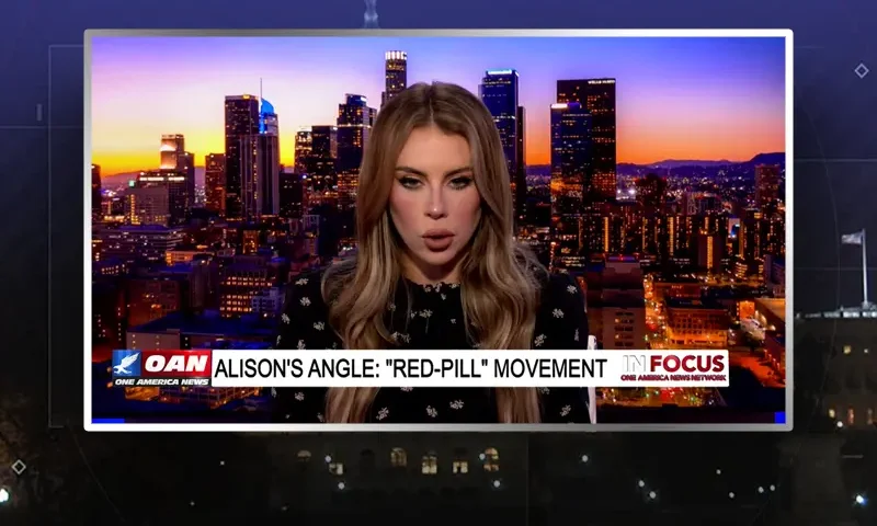Video still of the host of In Focus at the desk of their talk show on One America News Network.