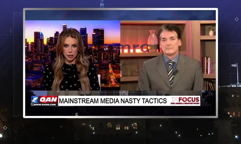 Video still from In Focus on One America News Network showing a split screen of the host on the left side, and on the right side is the guest, Eric Scheiner.