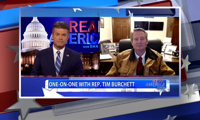 Video still from Real America on One America News Network showing a split screen of the host on the left side, and on the right side is the guest, Rep. Tim Burchett.
