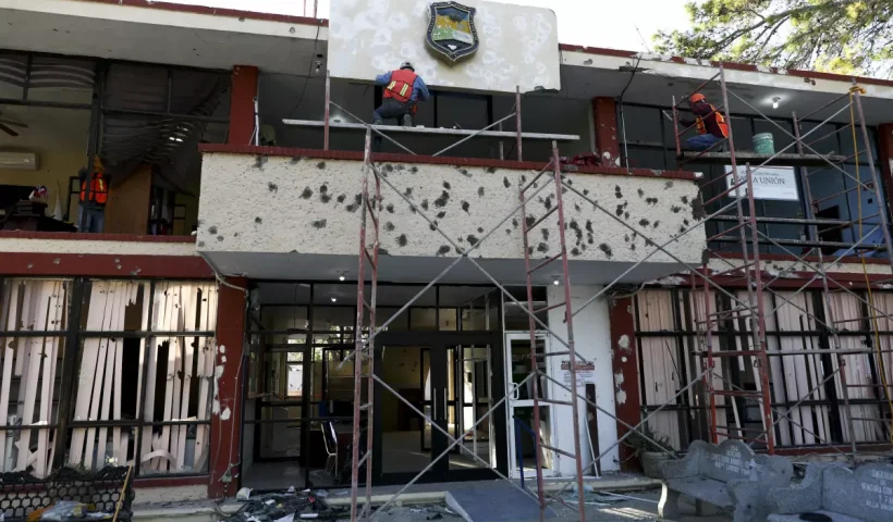 FILE - Workers repair the entrance of City Hall riddled in large bullet holes in Villa Union, Mexico, Dec. 2, 2019, after 22 people were killed in a weekend gun battle between a drug cartel and security forces. Mexico wants an urgent investigation into how U.S. military-grade weapons are increasingly being found in the hands of Mexican drug cartels, Mexico's top diplomat said on Jan. 22, 2024. (AP Photo/Eduardo Verdugo, File)
