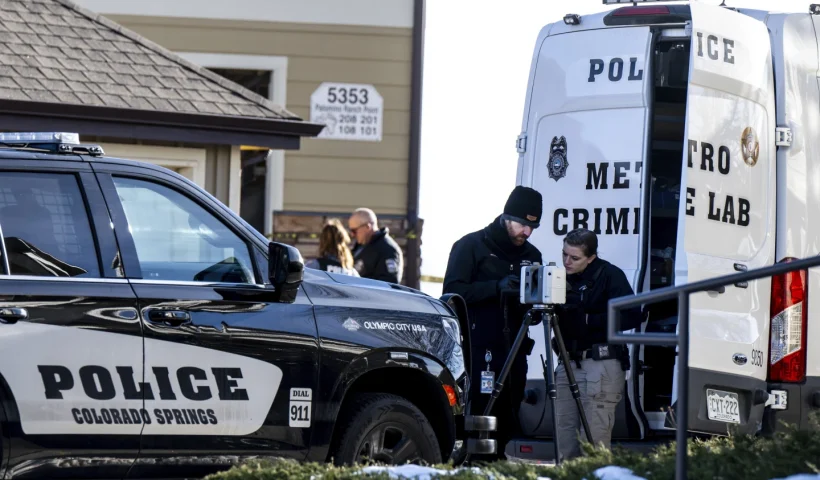 Colorado Springs Police Department investigators and officers work on the scene after responding to a 911 call reporting a burglary where they found children dead inside a condo of the Palomino Ranch Point complex on Tuesday, Dec. 19, 2023 in Colorado Springs, Colo. A woman was being sought Thursday on suspicion of killing her two young children and wounding a third, authorities said. (Parker Seibold/The Gazette via AP)