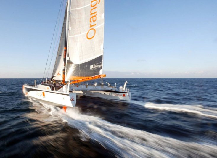 le maxi-catamaran "Orange II", skippé par le Français Bruno Peyron, navigue aux allures de grand largue le 18 février 2004 au large de l'île d'Ouessant, après avoir passé la ligne de départ du "Trophée Jules Verne", tour du monde en équipage à la voile sans escale. Bruno Peyron, avec l'aide de ses 14 membres d'équipage, tente de battre le record de la course qu'il détient depuis le 05 mai 2002 en 64 jours 8 heures 37 minutes et 2' secondes. AFP PHOTO MARCEL MOCHET (Photo by MARCEL MOCHET / AFP) (Photo by MARCEL MOCHET/AFP via Getty Images)