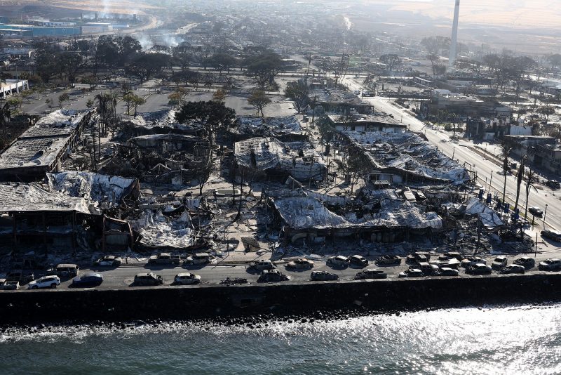 LAHAINA, HAWAII - AUGUST 11: In an aerial view, cars destroyed by wildfire line Front Street on August 11, 2023 in Lahaina, Hawaii. Dozens of people were killed and thousands were displaced after a wind-driven wildfire devastated the town of Lahaina on Tuesday. Crews are continuing to search for missing people. (Photo by Justin Sullivan/Getty Images)