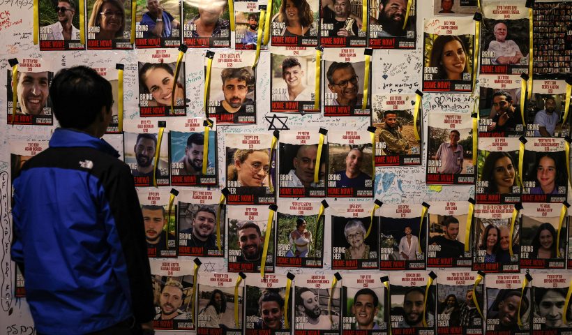 TOPSHOT - A man looks at posters bearing the images of Israeli hostages held in Gaza since the October 7 attack on the sidelines of a demonstration calling for their release, in Tel Aviv on December 2, 2023. Israel and Hamas brushed off international calls to renew an expired truce on December 2 as air strikes pounded militant targets in Gaza and Palestinian groups launched volleys of rockets. (Photo by AHMAD GHARABLI / AFP) (Photo by AHMAD GHARABLI/AFP via Getty Images)
