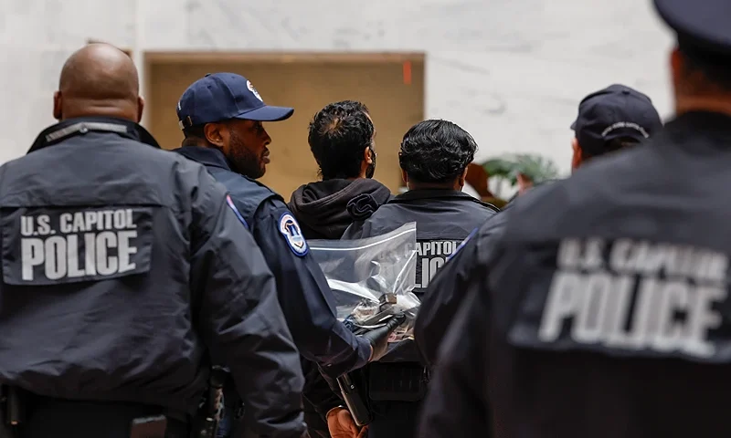WASHINGTON, DC - DECEMBER 11: United States Capitol Police arrest a protester after he climbed down the "Mountains and Clouds" sculpture inside the atrium of the Hart Senate Office Building on December 11, 2023 in Washington, DC. The protester climbed the sculpture during a demonstration with pro-Palestinian activists on Capitol Hill. (Photo by Anna Moneymaker/Getty Images)