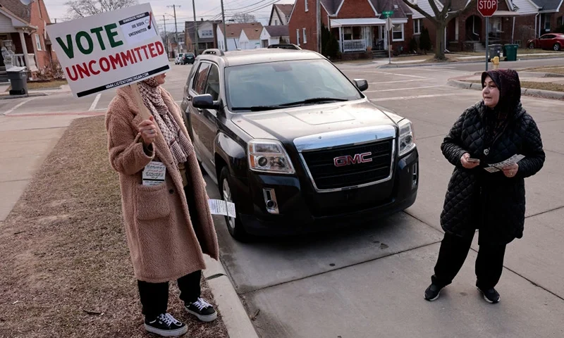 Aruba Obeid (L) asks voters to cast an uncommitted ballot, instead of voting for US President Joe Biden outside of Maples Elementary School in Dearborn during the Michigan presidential primary election on February 27, 2024. Michigan's primary is expected to be another ticker-tape parade for former US President Donald Trump, but could deliver Democratic leader Joe Biden a bloody nose over the war in Gaza. (Photo by JEFF KOWALSKY / AFP) (Photo by JEFF KOWALSKY/AFP via Getty Images)