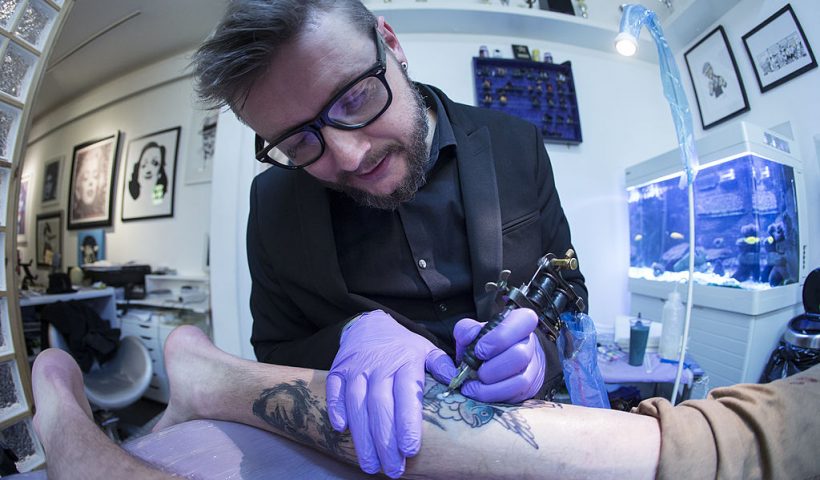 LONDON, ENGLAND - APRIL 22: Artist and tattooist Dan Gold creates a tattoo featuring an image of Albert Einstein in his West Hampstead studio on April 22, 2014 in London, England. Dan Gold is one of the world's most prominent tattooists whose unique, bold and often colourful style is a mixture of traditional tattoo art and graffiti. Dan Gold has tattooed numerous famous clients including Kate Moss and Britney Spears; he has also been instrumental in reducing the stigma associated with tattoos. The popularity of tattoos has increased dramatically over the past few years, aided by several high profile people such as: David Beckham, Samantha Cameron and Cheryl Cole being tattooed. (Photo by Oli Scarff/Getty Images)