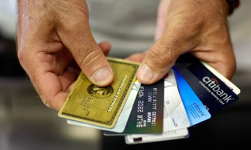 MIAMI - MAY 20: Alain Filiz shows off some of his credit cards as he pays for items at Lorenzo's Italian Market on May 20, 2009 in Miami, Florida. Members of Congress today passed a bill placing new restrictions on companies that issues credit. The vote follows the Senate passage of the bill, which now heads for President Obama's promised signature. The bill will curb sudden interest rate increases and hidden fees, requiring card companies to tell customers of rate increases 45 days in advance. It will also make it harder for people aged below 21 to be issued credit cards. (Photo by Joe Raedle/Getty Images)