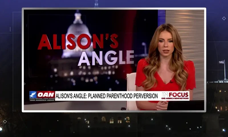 Video still of the host of In Focus at the desk of their talk show on One America News Network.