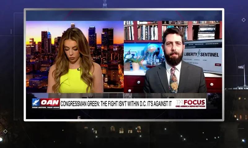 Video still from In Focus on One America News Network showing a split screen of the host on the left side, and on the right side is the guest, Alex Newman.