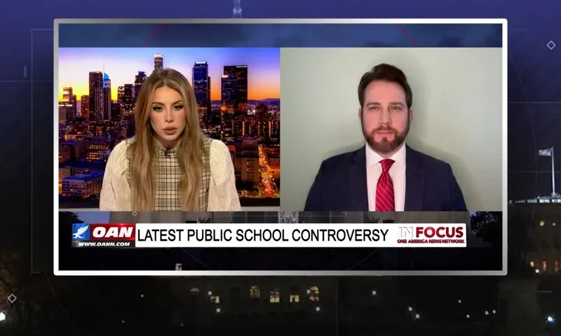 Video still from In Focus on One America News Network showing a split screen of the host on the left side, and on the right side is the guest, William Wolfe.