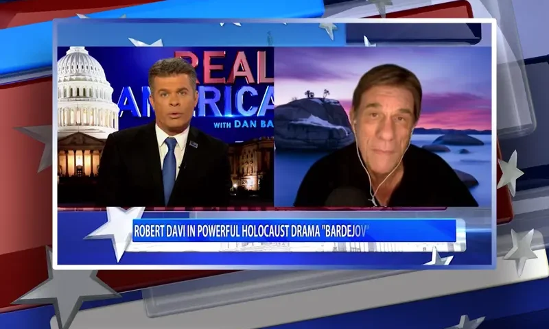 Video still from Real America on One America News Network showing a split screen of the host on the left side, and on the right side is the guest, Robert Davi.