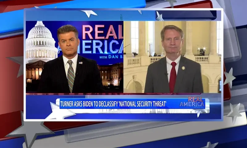 Video still from Real America on One America News Network showing a split screen of the host on the left side, and on the right side is the guest, Rep. Tim Burchett.