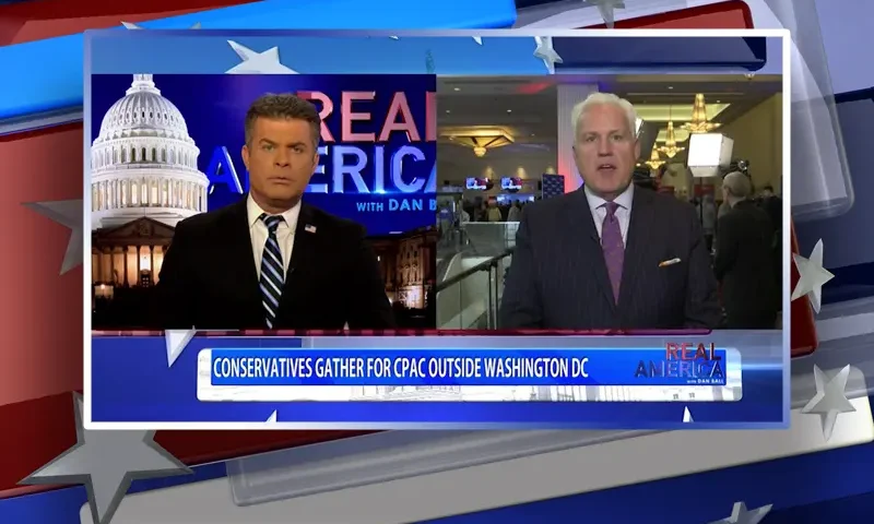 Video still from Real America on One America News Network showing a split screen of the host on the left side, and on the right side is the guest, Matt Schlapp.