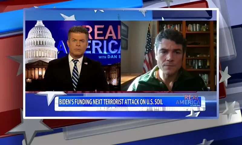Video still from Real America on One America News Network showing a split screen of the host on the left side, and on the right side is the guest, Joe Kent.