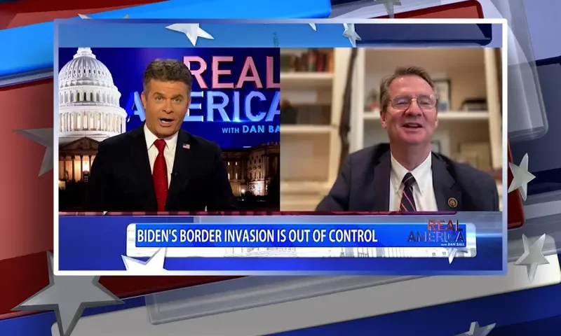 Video still from Real America on One America News Network showing a split screen of the host on the left side, and on the right side is the guest, Rep. Tim Burchett.