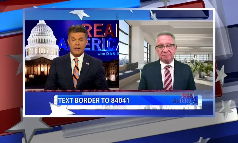 Video still from Real America on One America News Network showing a split screen of the host on the left side, and on the right side is the guest, Bill Wells.