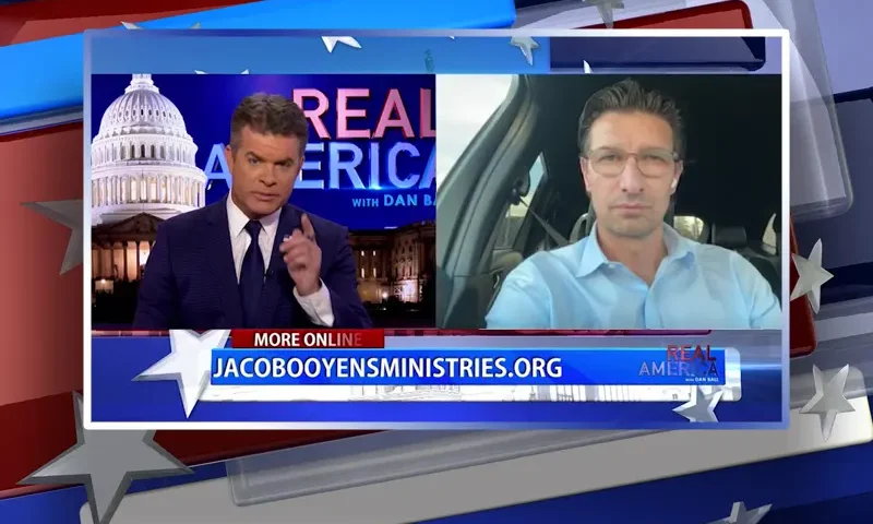 Video still from Real America on One America News Network showing a split screen of the host on the left side, and on the right side is the guest, Jaco Booyens.