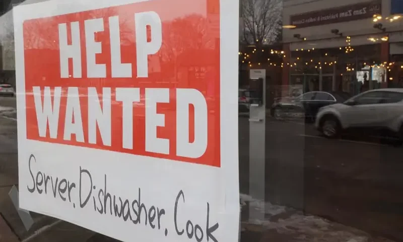 A "Help Wanted" sign hangs in a restaurant window in Medford, Massachusetts, U.S., January 25, 2023. REUTERS/Brian Snyder/File Photo