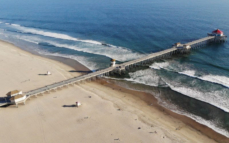 HUNTINGTON BEACH, CALIFORNIA - MARCH 28: An aerial view of Huntington Beach and its shuttered pier amid the coronavirus pandemic on March 28, 2020 in Huntington Beach, California. The city of Huntington Beach has closed its pier and parking lots along the beach in efforts to limit the spread of COVID-19 although the beach itself remains open. (Photo by Mario Tama/Getty Images)