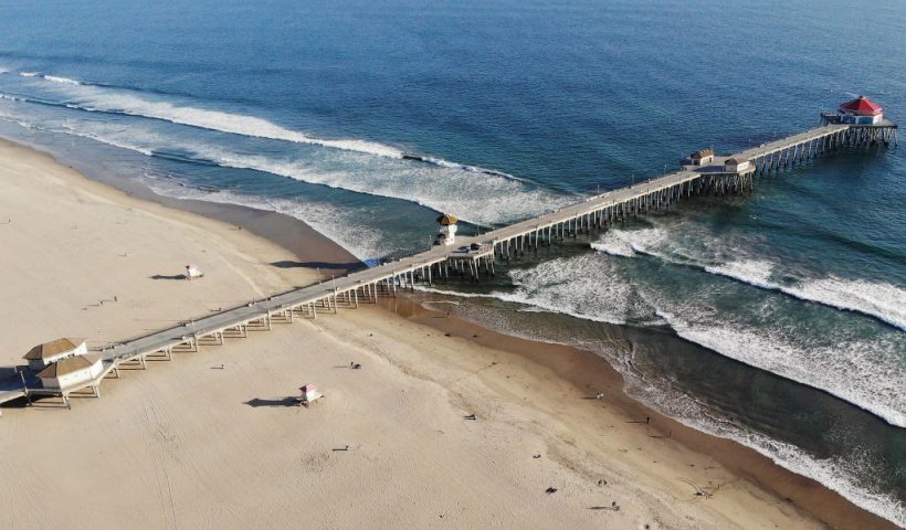 HUNTINGTON BEACH, CALIFORNIA - MARCH 28: An aerial view of Huntington Beach and its shuttered pier amid the coronavirus pandemic on March 28, 2020 in Huntington Beach, California. The city of Huntington Beach has closed its pier and parking lots along the beach in efforts to limit the spread of COVID-19 although the beach itself remains open. (Photo by Mario Tama/Getty Images)