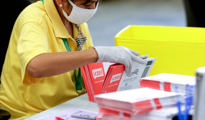 An election worker opens envelopes containing vote-by-mail ballots for the August 4 Washington state primary at King County Elections in Renton, Washington on August 3, 2020.A sign explaining signature verification is pictured as vote-by-mail ballots for the August 4 Washington state primary are processed at King County Elections in Renton, Washington on August 3, 2020. (Photo by Jason Redmond / AFP) (Photo by JASON REDMOND/AFP via Getty Images)