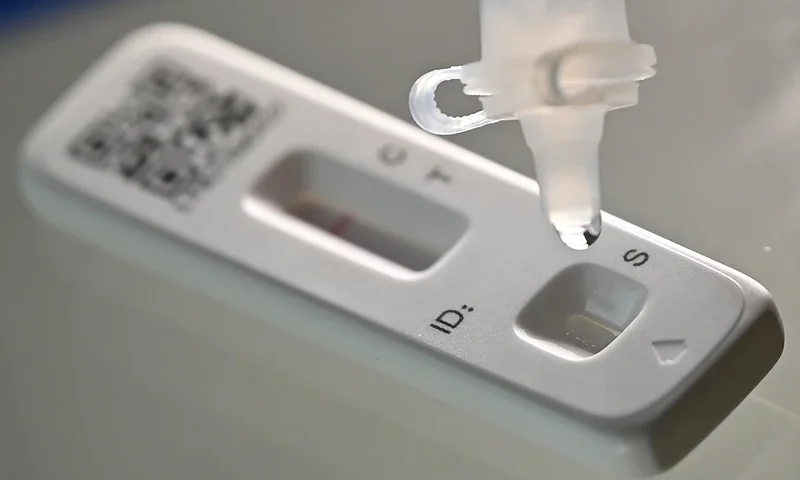 BRITAIN-HEALTH-VIRUS-TEST An illustration picture taken on February 20, 2022 shows a model using a SARS-CoV-2 Antigen Rapid Test contained in a Covid-19 Lateral Flow (LFT) self-test kit, in London. (Photo by Justin TALLIS / AFP) (Photo by JUSTIN TALLIS/AFP via Getty Images)
