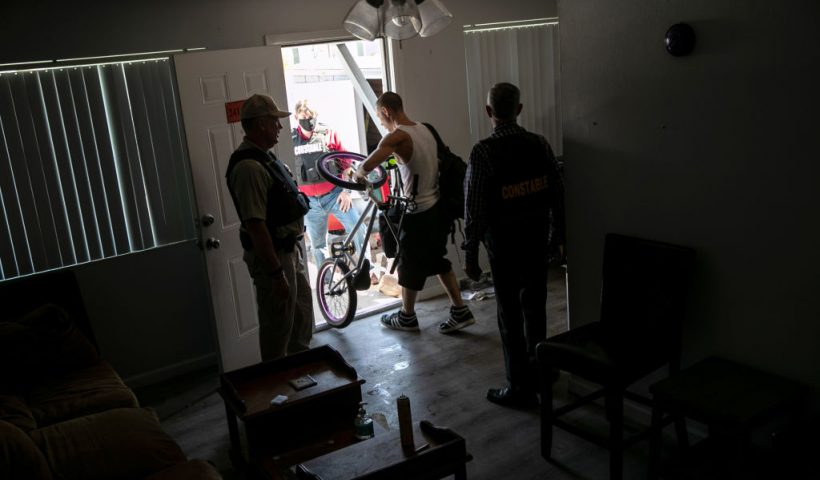 PHOENIX, ARIZONA - SEPTEMBER 30: A squatter removes belongings from an apartment as Maricopa County constables serve an eviction order on September 30, 2020 in Phoenix, Arizona. Squatters had occupied the apartment after non-paying tenants had moved out. Thousands of court-ordered evictions continue nationwide despite a Centers for Disease Control (CDC) moratorium for renters impacted by the coronavirus pandemic. Although state and county officials say they have tried to educate the public on the protections, many renters remain unaware and fail to complete the necessary forms to remain in their homes. In many cases landlords have worked out more flexible payment plans with vulnerable tenants, although these temporary solutions have become fraught as the pandemic drags on. With millions of Americans still unemployed due to the pandemic, federal rental assistance proposals remain gridlocked in Congress. The expiry of the CDC moratorium at year's end looms large, as renters and landlord face a potential tsunami of evictions and foreclosures nationwide. (Photo by John Moore/Getty Images)