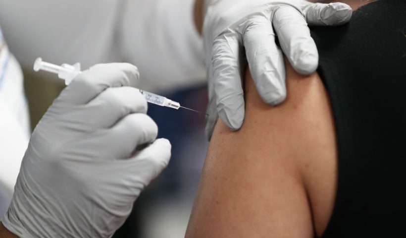 MIAMI, FLORIDA - DECEMBER 15: A healthcare worker at the Jackson Health Systems receives a Pfizer-BioNtech Covid-19 vaccine from Susana Flores Villamil, RN from Jackson Health Systems, at the Jackson Memorial Hospital on December 15, 2020 in Miami, Florida. Jackson Memorial Hospital began the vaccination of frontline healthcare workers joining with hospital systems around the country as the COVID-19 vaccine is rolled out. (Photo by Joe Raedle/Getty Images)