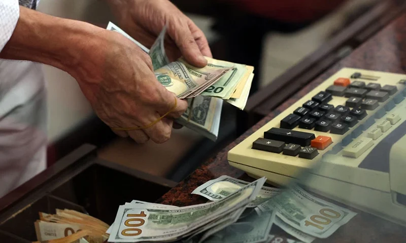 A teller counts US dollar bills at an exchange office in Ankara on July 20, 2023. Turkey's central bank hiked its main interest rate for the second month in a row, but analysts said the unwinding of President Recep Tayyip Erdogan's unconventional policy was too timid to tame inflation. After years of cuts that aimed to boost growth but fuelled inflation and caused the lira to tumble, the bank doubled its rate last month from 8.5 percent to 15 percent. The latest hike was smaller, at 2.5 percentage points, taking the rate to 17.5 percent. (Photo by Adem ALTAN / AFP) (Photo by ADEM ALTAN/AFP via Getty Images)