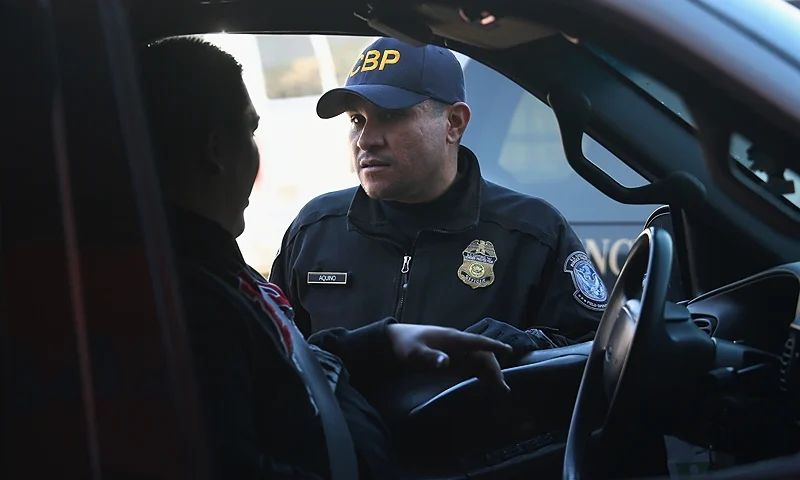 NOGALES, AZ - FEBRUARY 26: An Customs and Border Protection officer from the U.S. Office of Field Operations (OFO), speaks with a motorist crossing from Mexico into the United States on February 26, 2013 in Nogales, Arizona. Some 15,000 people cross between Mexico and the U.S. each day in Nogales, Arizona's busiest border crossing. (Photo by John Moore/Getty Images)