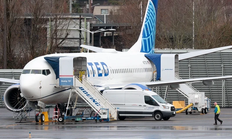 TOPSHOT-US-ACCIDENT-AVIATION-BOEING TOPSHOT - A person walks past a Boeing 737 MAX 8 for United Airlines parked at Renton Municipal Airport adjacent to Boeing's factory in Renton, Washington, on January 25, 2024. Alaska Airlines said Thursday it expects a $150 million hit from the Boeing 737 MAX grounding, which will limit its capacity growth in 2024. The airline, which executed an emergency landing on a MAX on January 5 following the mid-flight blowout of a panel on the jet, disclosed the estimates in a securities filing, saying capacity growth will be "at or below the lower end" of its prior estimate. (Photo by Jason Redmond / AFP) (Photo by JASON REDMOND/AFP via Getty Imag