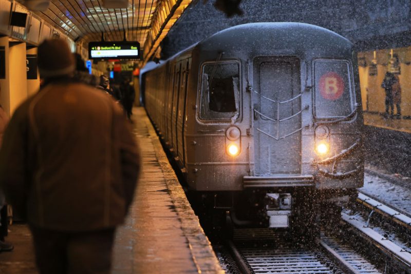 NEW YORK, NEW YORK - FEBRUARY 13: People walk along the Church Avenue subway station platform as a train arrives amid a winter storm on February 13, 2024 in the Flatbush neighborhood of Brooklyn borough in New York City. The biggest winter storm in two years is hitting the Northeast with NYC forecasted to get three to five inches of snow. In anticipation of the storm, Mayor Eric Adams announced that schools would be going fully remote today. (Photo by Michael M. Santiago/Getty Images)
