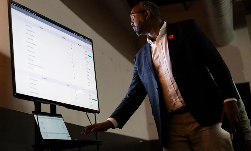 Jaylani Hussein, an activist with the Uncommitted Minnesota and National #AbandonBiden campaign, sets up a TV to broadcast results at an Uncommitted Minnesota watch party during the presidential primary in Minneapolis, Minnesota on Super Tuesday, March 5, 2024. The group organized people to vote "uncommitted" in the Democratic primary election as a form of protest against the Biden administration's handling of the war in Gaza. Americans from 15 states and one territory vote simultaneously on "Super Tuesday," a campaign calendar milestone expected to leave Donald Trump a hair's breadth from securing the Republican Party's presidential nomination. (Photo by STEPHEN MATUREN / AFP) (Photo by STEPHEN MATUREN/AFP via Getty Images)