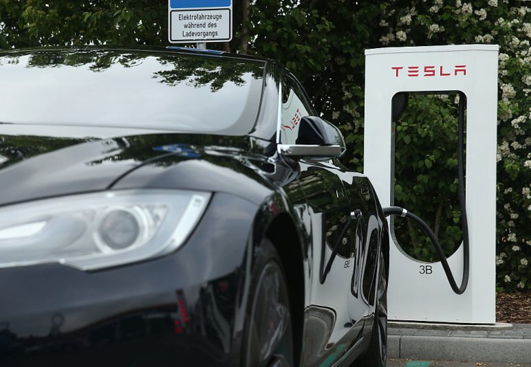 RIEDEN, GERMANY - JUNE 11: A Tesla electric-powered sedan stands at a Tesla charging staiton at a highway reststop along the A7 highway on June 11, 2015 near Rieden, Germany. Tesla has introduced a limited network of charging stations along the German highway grid in an effort to raise the viability for consumers to use the cars for longer journeys. (Photo by Sean Gallup/Getty Images)