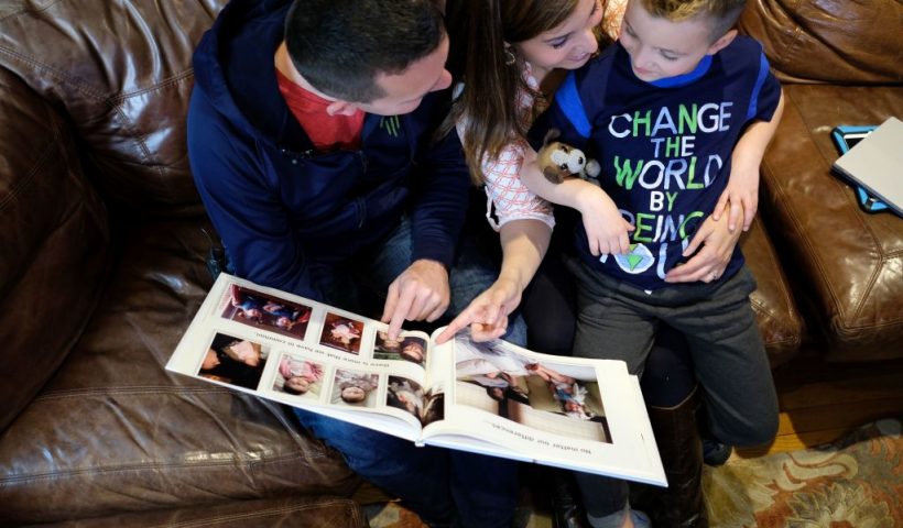 Seven-year-old transgender boy Jacob Lemay and his parents Joe and Mimi look at their family photo before his transition at their home in Melrose, Massachusetts, on May 9, 2017.